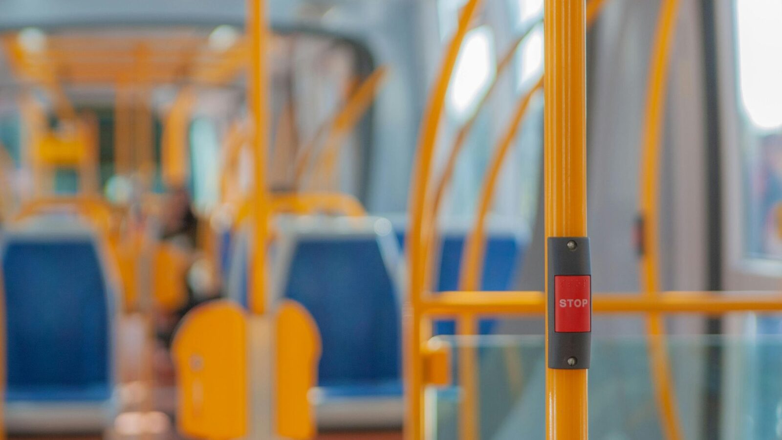 Interior view of a bus with seats and STOP button
